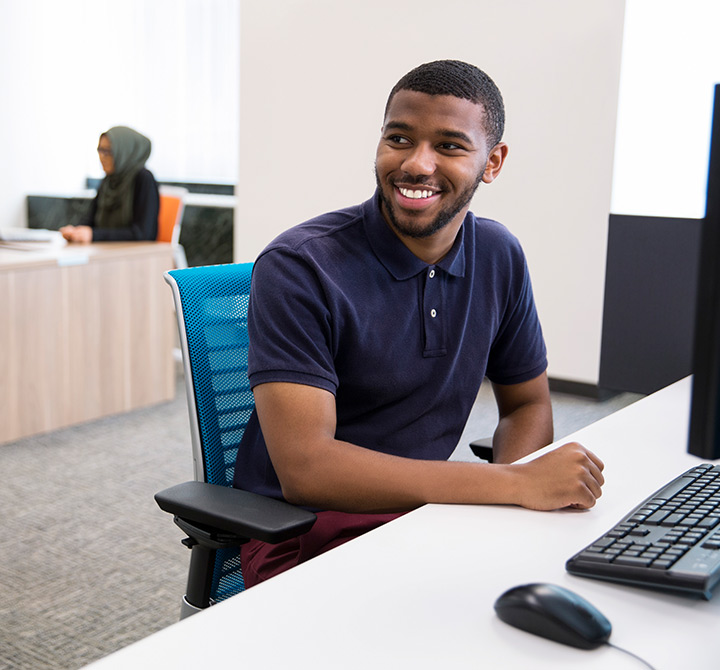 Man seated at computer desk.