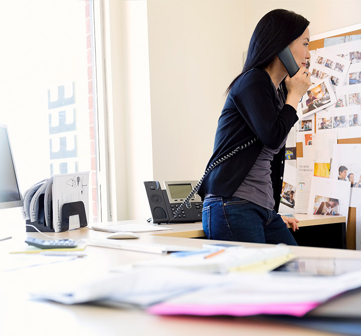Woman in office on a landline phone.