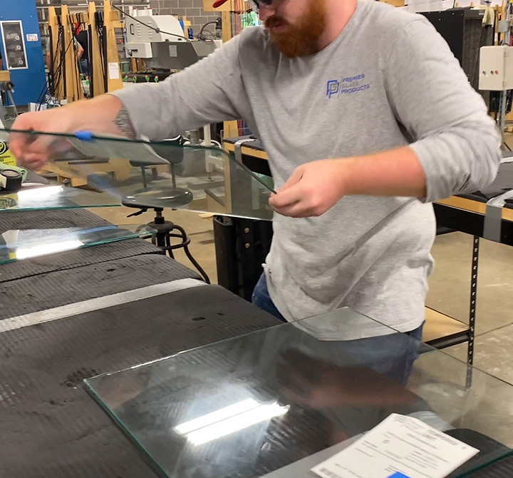 PMG Ventures employee working in the warehouse making a sneeze guard.