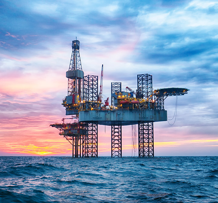 Oil rig at sea at sunset.