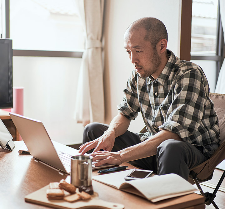 Man at home desk on his laptop.