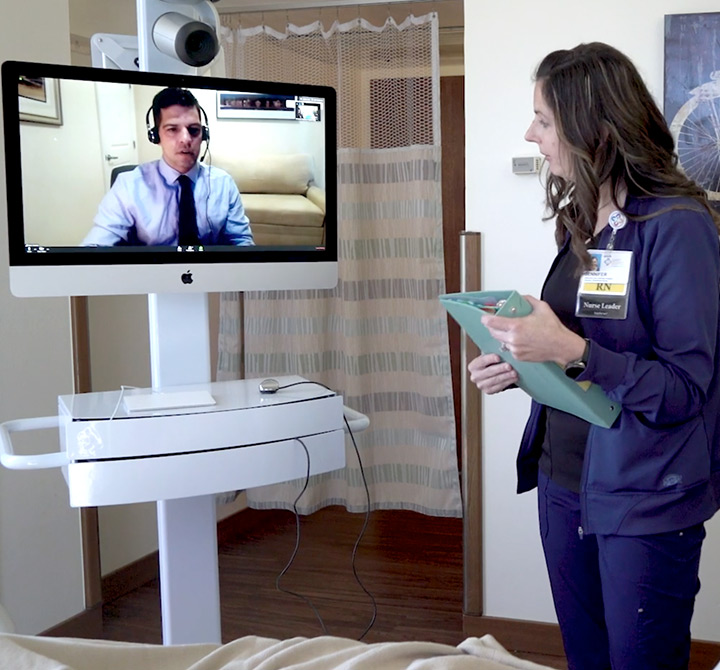 Doctor on screen speaking to female physician