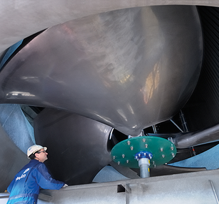 Howden employee in hardhat looking at large machinery. 