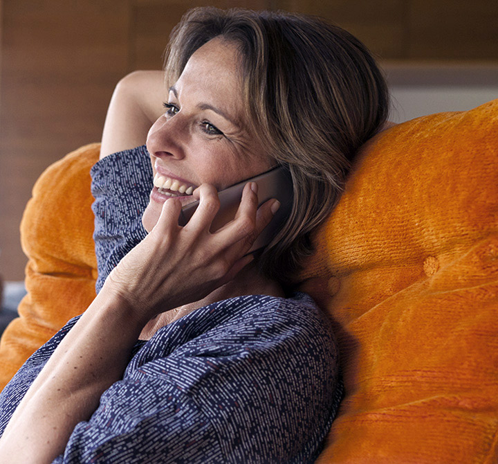 Woman smiling while on her smartphone. 