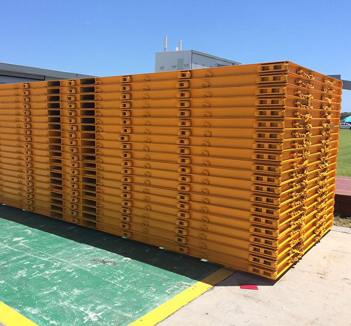 Stacked yellow metal freight skids for shipping