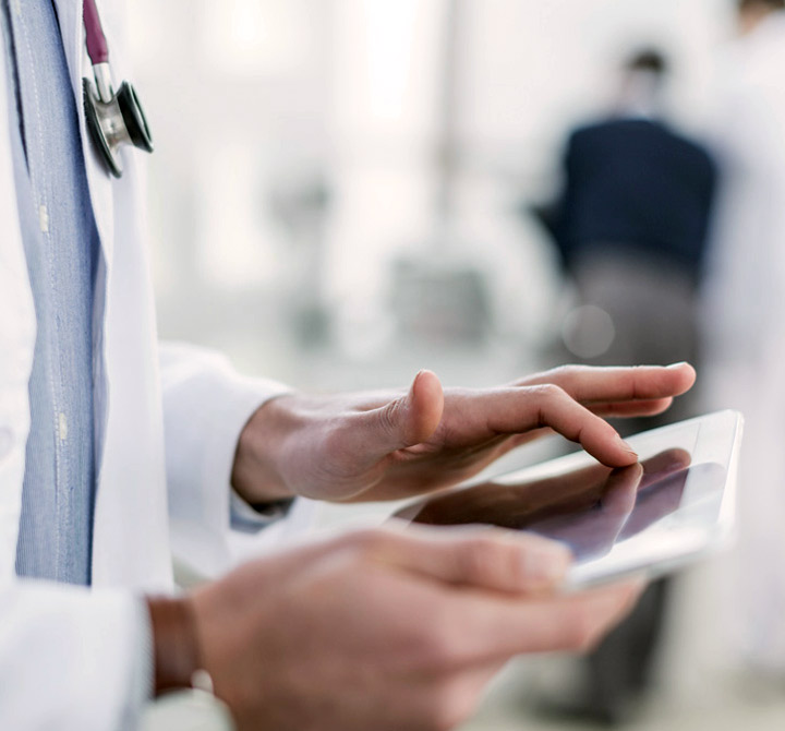 Doctor's hands holding a tablet.