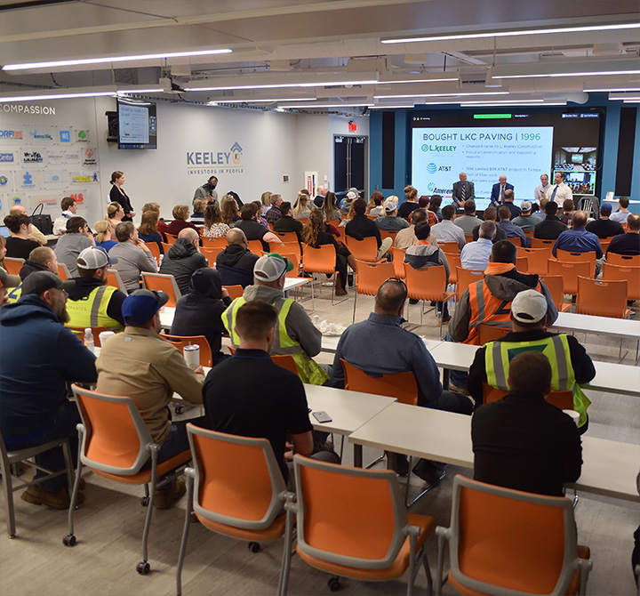 Keeley employees in large presentation room.