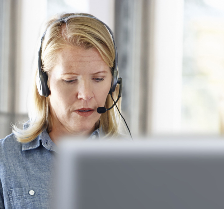 Woman on computer wearing a call headset.