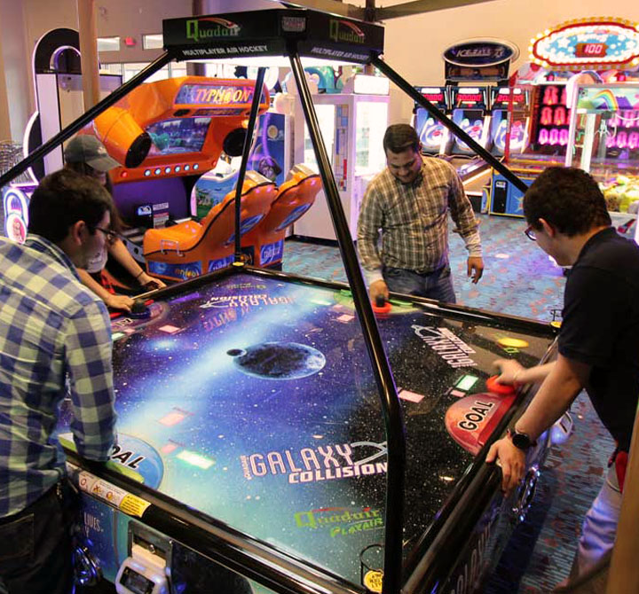 Men playing an arcade game at PLA-MOR Entertainment Center, powered by AT&T Dedicated Internet and Business WiFi. 