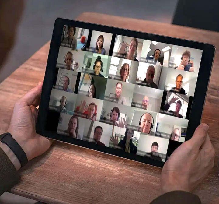 A tablet showing lots of people on a video conference meeting.