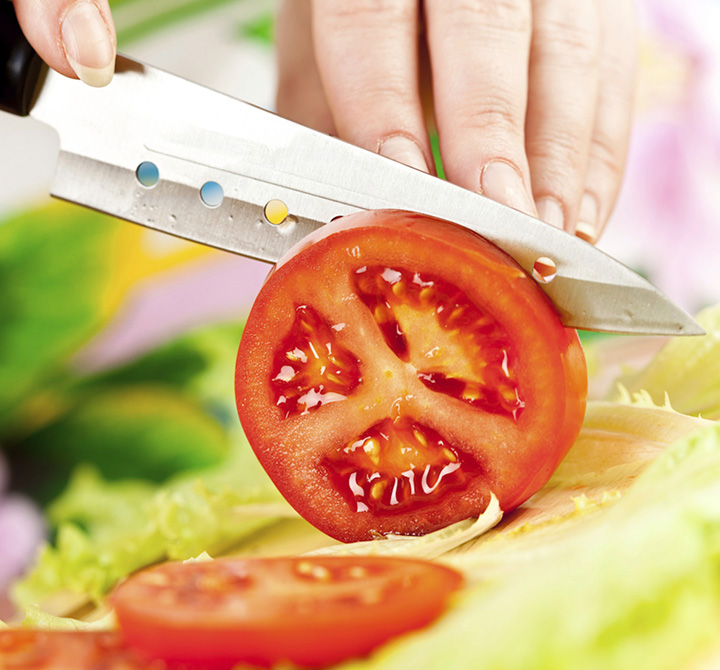 Zoomed in image of tomato being sliced.