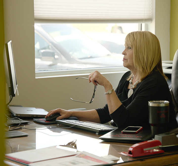 Kim Dupree with State Farm Insurance sitting at her desk.