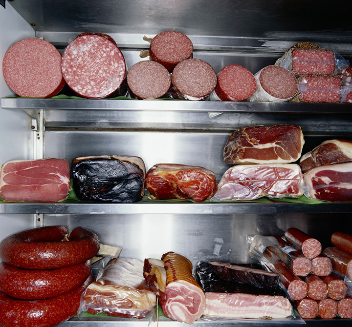 Various deli meats in stainless steal meat fridge.