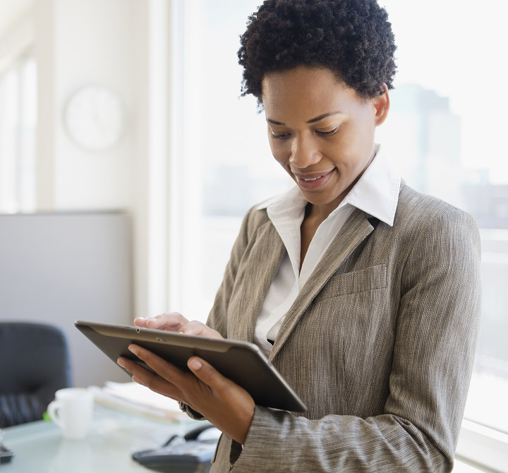 Business woman holding a tablet in an office.
