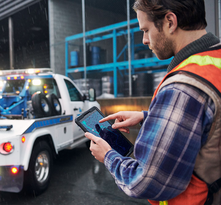 Tow truck driver using a tablet.