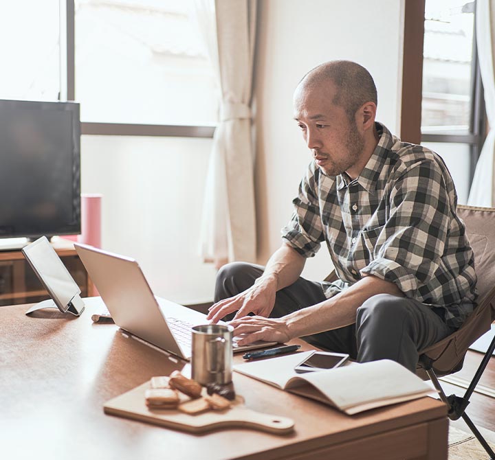 Man working on laptop in living room.