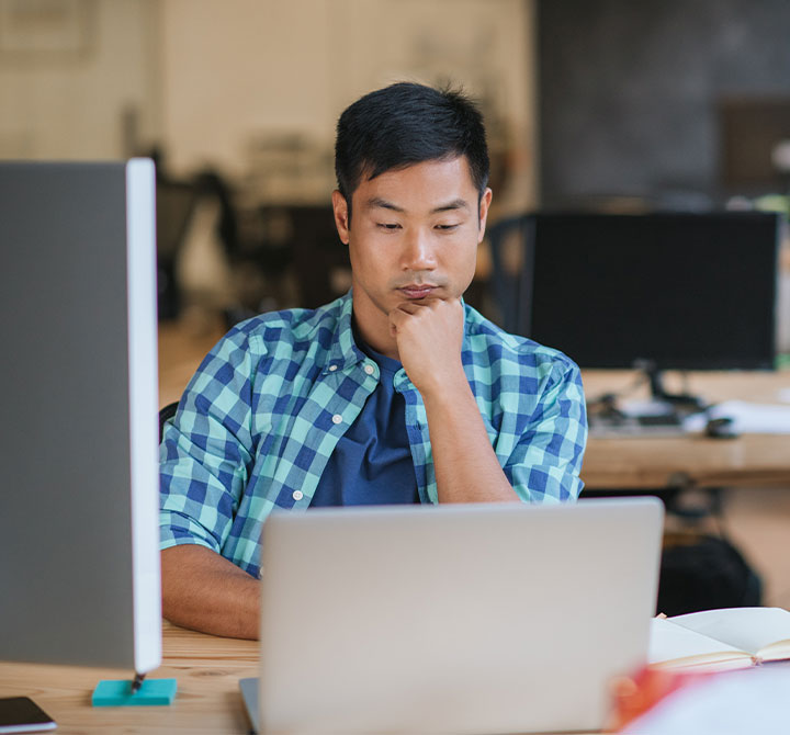 Man working at laptop in office.