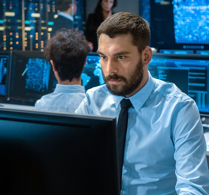 Man looking at computer in Security Operations Center.