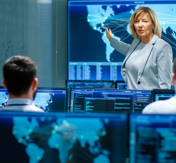 Woman pointing at screen in Security Operations Center.
