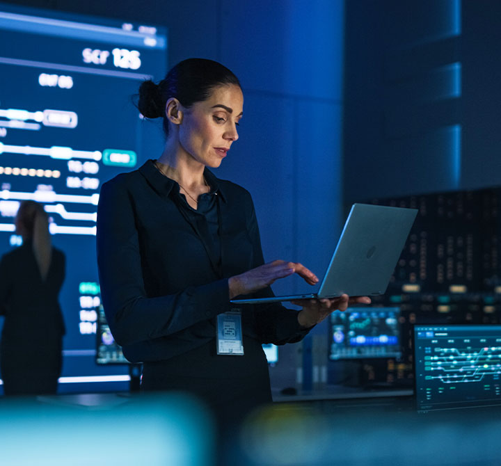 Woman working on laptop in Security Operation Center.