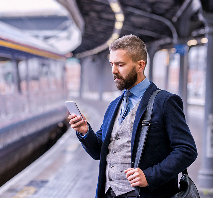 Business man in subway looking at smart phone. 