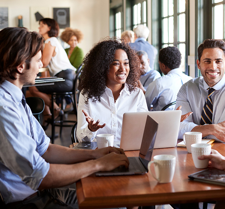 Business associates working remotely in a public cafe