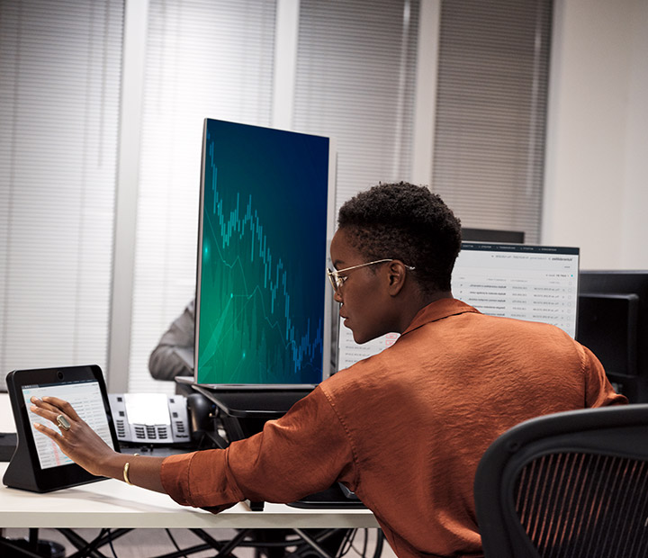 Woman sitting at desk using connected devices with fiber connectivity.