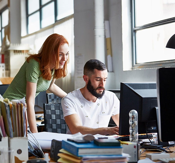 Coworkers meeting at office desk