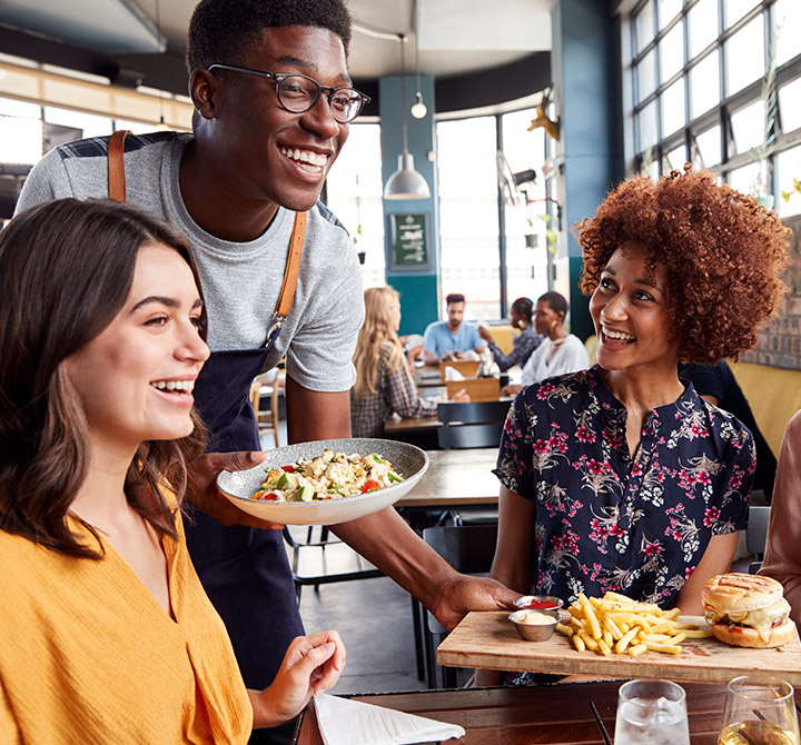 Woman eating a burgers and fries at restaurant