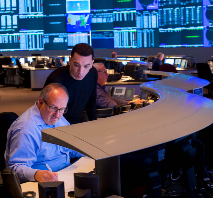Two men having a discussion in a security operations center.