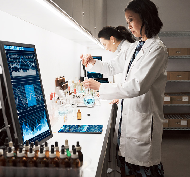 Scientist experimenting with data tablets and screens