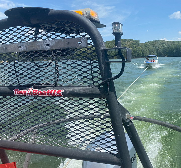 Inside a TowBoatUs boat providing a boat towing service to a recreational boat, connected with a long cord.