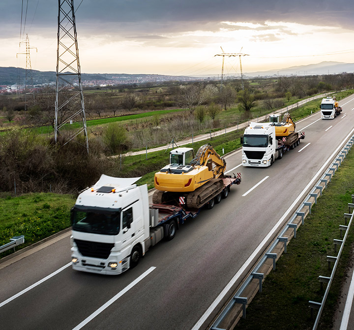Semi trucks transporting construction equipment