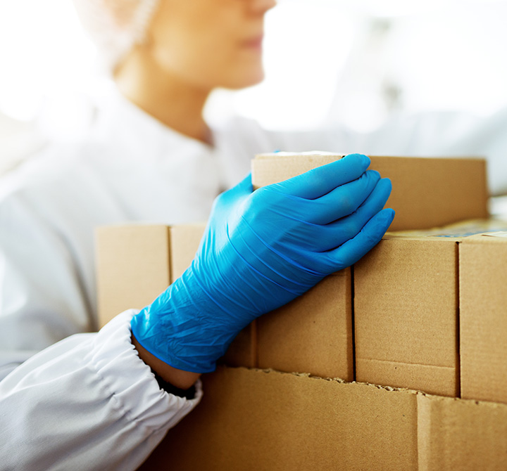 Woman packing boxes wearing latex gloves