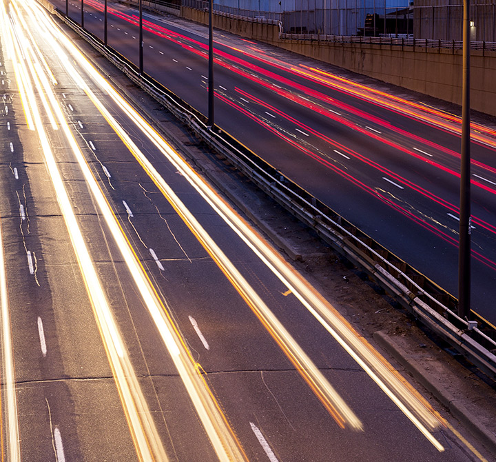 Arial view of expressway at night with blurred vehicle lights. 