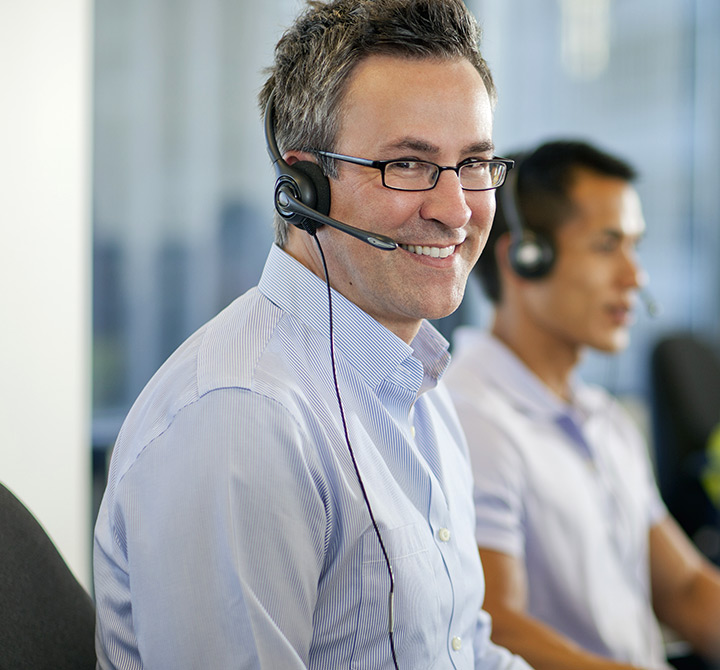 Man at call center with headset on.