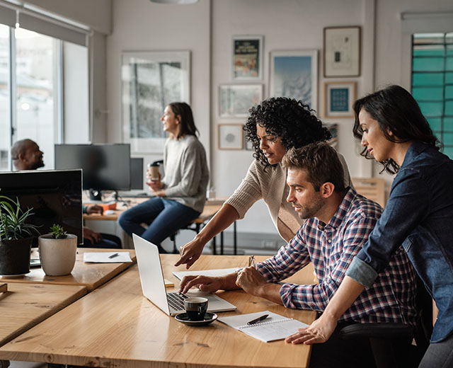 Coworkers around a laptop