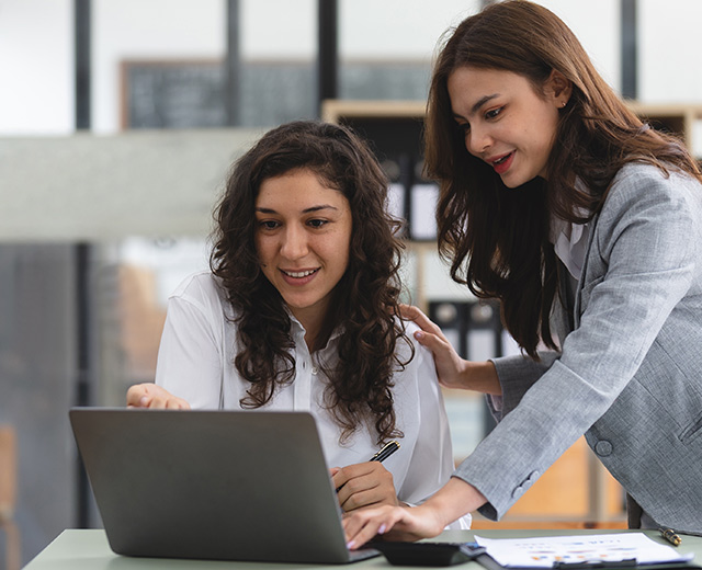 Business associates viewing a laptop together in an office