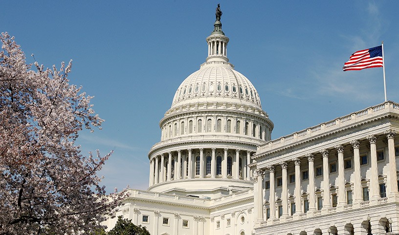 View of the U.S. Capitol building with the American flag flying atop it.