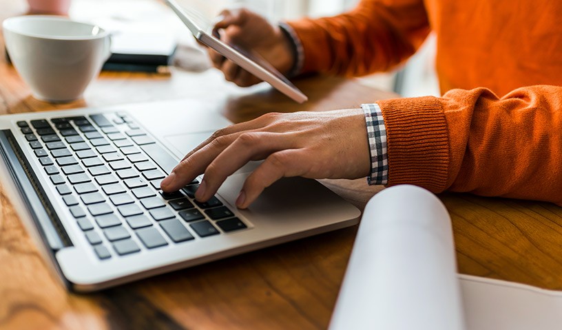 Professional using laptop and tablet