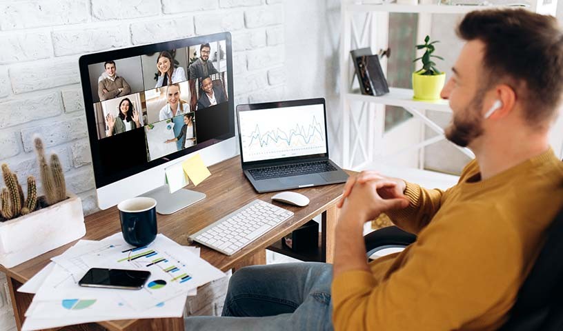 Professional on a conference call with monitor and laptop