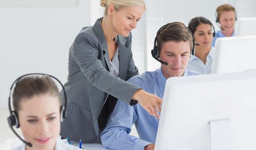 Manager helping call centre employee in the office