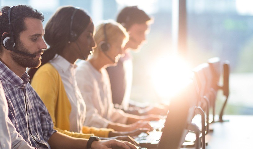 Team of colleagues working at their desk with headset in the office