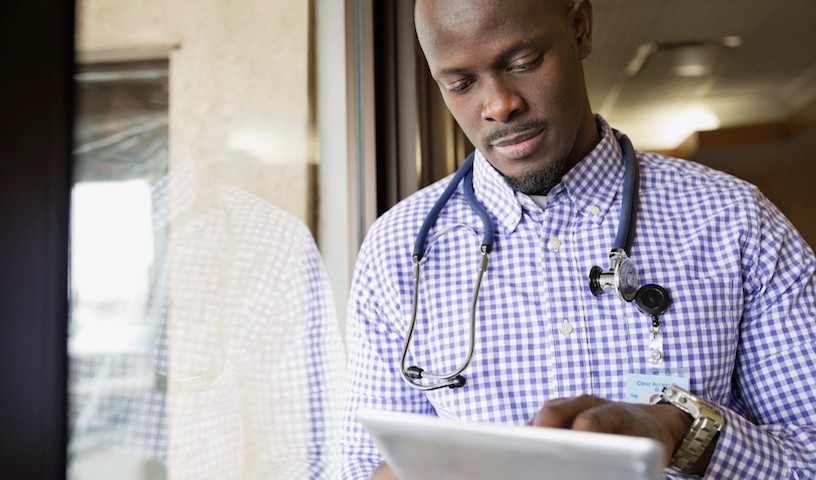 Male doctor using digital tablet in clinic