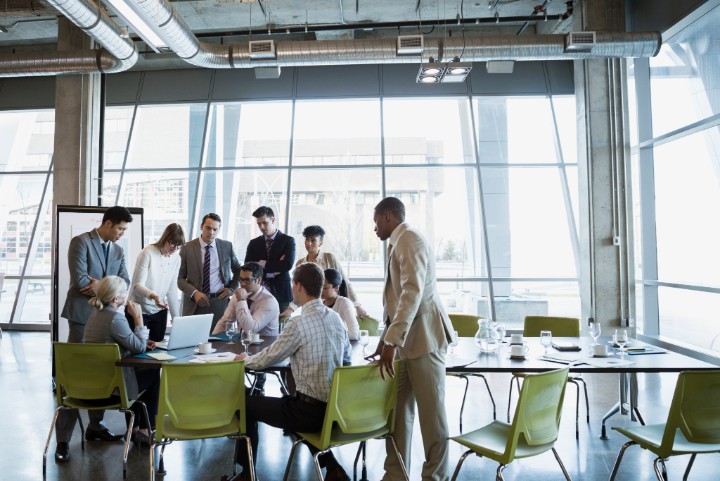 Business people meeting around laptop in conference room