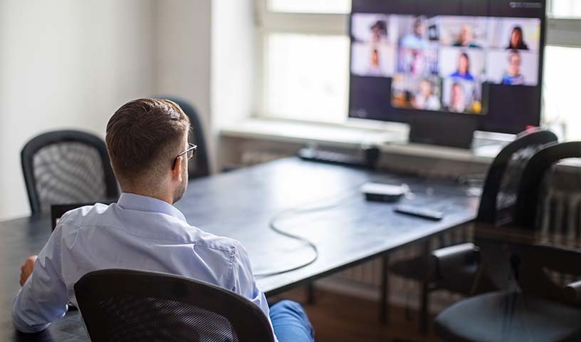 Male law firm employee is staying connected by attending a video conference call in a hybrid work environment.