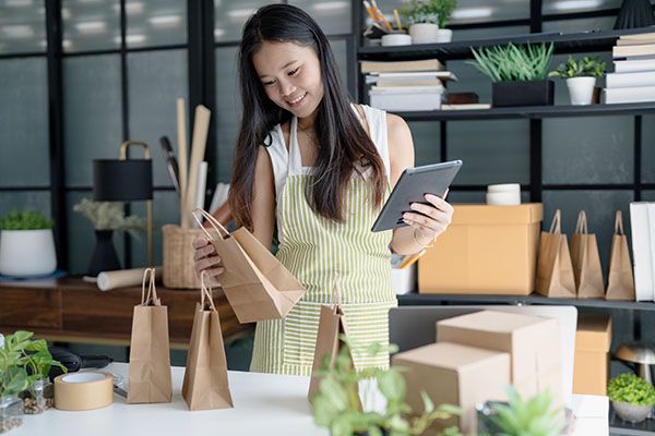 Small Business Owner Using Tablet to Check Orders and Prepare Products for Sale.