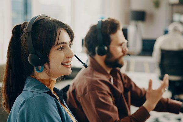 Coworking, woman and smile with headset, call center or friendly to contact, communication or sales. Business, consultant and people with tech for telemarketing, happy and explaining service with mic.