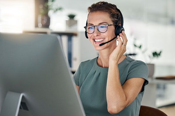 Happy, call center and computer, woman and headphones at desk, customer support or sales for telemarketing company. Mature agent or consultant, office and working, communication and customer service.