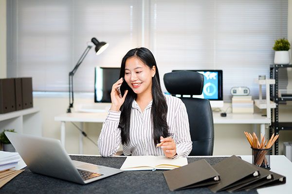 Young asian businesswoman beautiful charming smiling and talking on the mobile phone in the office..